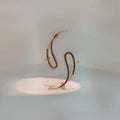 Gold snake-style ear crawler earring with black beaded detail